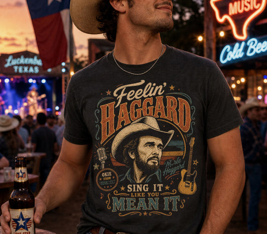 Man wearing a t-shirt with a graphic of a cowboy and text, holding a beer bottle in a lively bar setting.